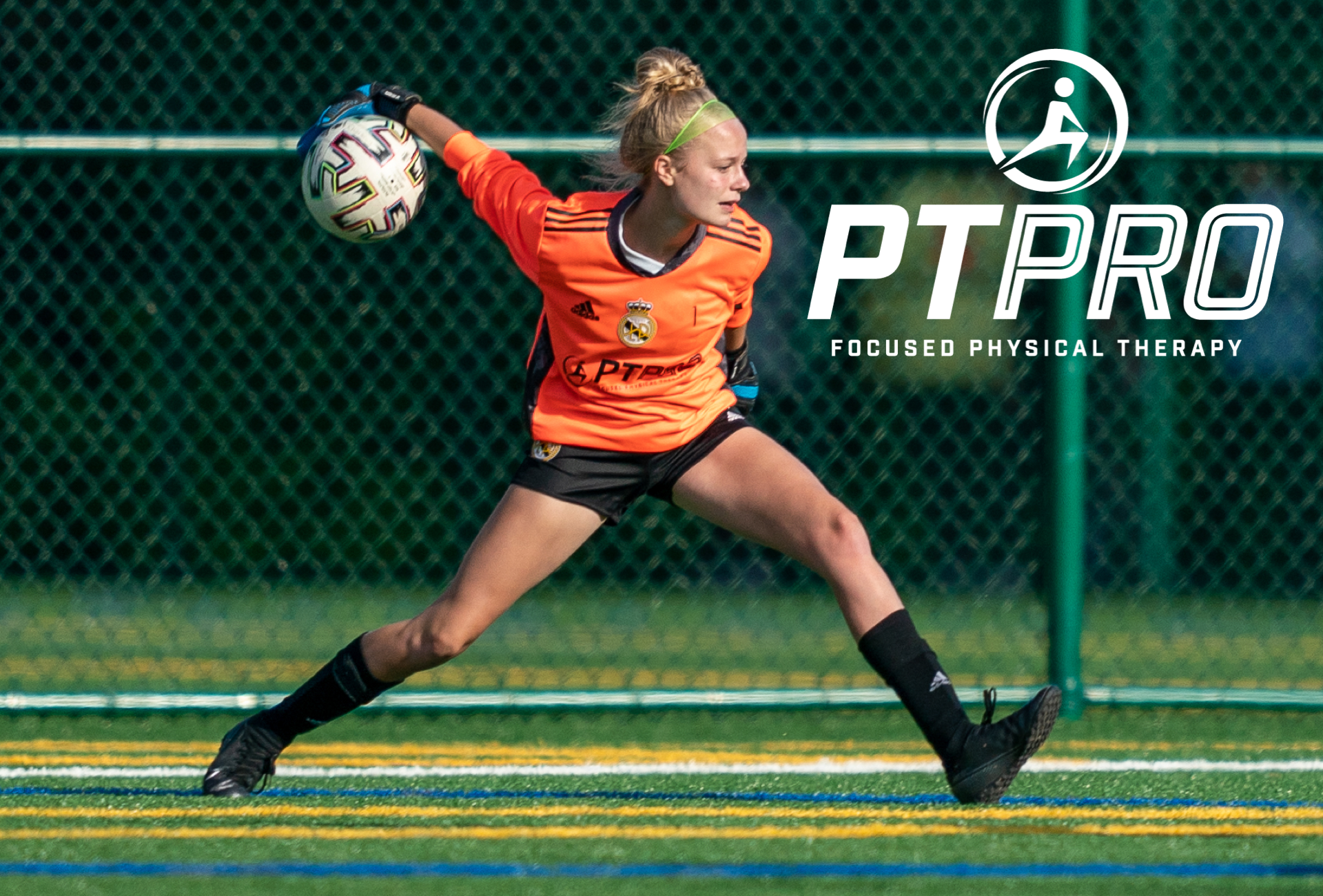 Female goalkeeper wearing orange jersey and black shorts throwing a soccer ball underarm with PTPRO logo in the image